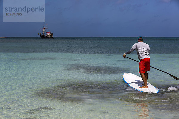 Mann beim Stand-up-Paddle-Boarding  Surfside Beach; Aruba'.