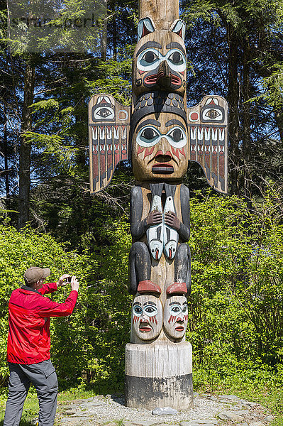 Tourist fotografiert einen Totempfahl  Totem Bight Historic State Park  Ketchikan  Südost-Alaska  USA  Frühling