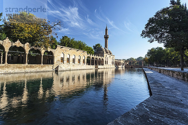 Die Kammer Abrahams und ein Minarett spiegeln sich im ruhigen Wasser eines Sees; Sanliurfa  Türkei'.