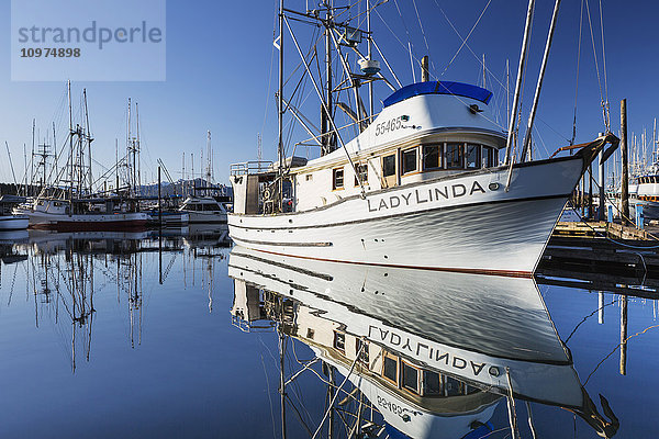 Das im Hafen von Sitka vertäute Fischerboot LadyLinda spiegelt sich an einem klaren Tag im ruhigen Wasser  Sitka  Südost-Alaska  USA  Sommer