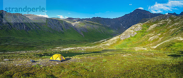 Ein Mann auf seinem Campingplatz im Hanging Valley in South Fork bei Eagle River an einem Sommertag in Süd-Zentral-Alaska.