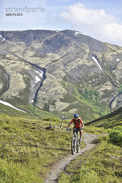Eine Frau fährt mit einem vollgefederten Mountainbike auf dem Resurrection Pass Trail im Chugach National Forest  Kenai Peninsula  Süd-Zentral-Alaska