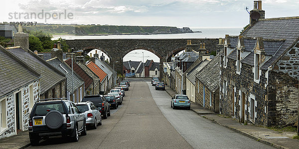 Eine von Häusern gesäumte Straße  die zum Meer hinunterführt; Cullen  Schottland'.