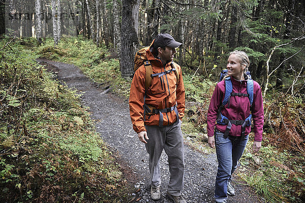 Ein Paar wandert auf einem bewaldeten Pfad im Chugach National Forest in Süd-Zentral-Alaska