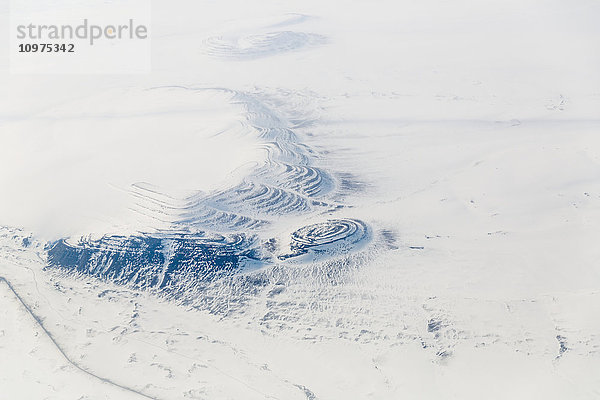 Luftaufnahme einer Ölfeldstraße  die an kleinen  schneebedeckten Hügeln in der Tundra vorbeiführt  North Slope  Arctic Alaska  USA  Winter