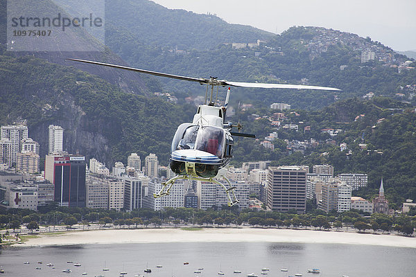 Sightseeing-Hubschrauber vom Zuckerhut aus gesehen  mit Blick auf die Bucht von Botafogo; Rio de Janeiro  Brasilien'.