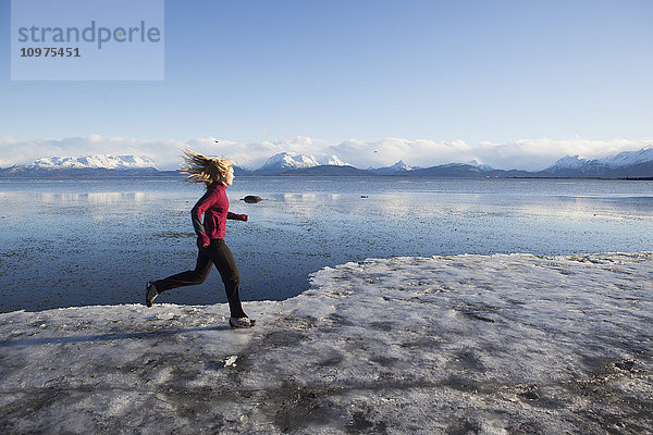 Frau läuft auf dem eisbedeckten Strand in Homer  Kenai-Halbinsel  Süd-Zentral-Alaska
