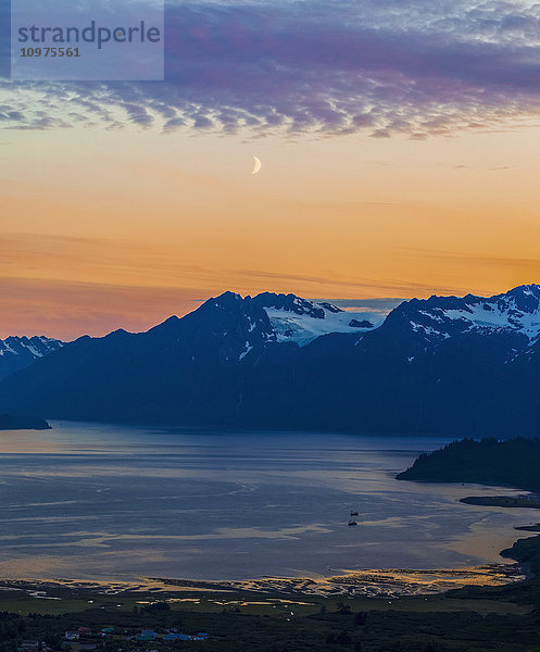 Der Mond hängt im Sonnenuntergang über Port Valdez und den Chugach Mountains südlich von Valdez; Alaska  Vereinigte Staaten von Amerika'.