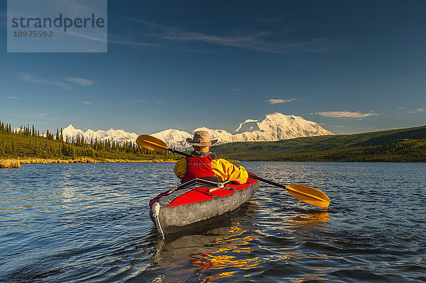 Mann beim Kajakfahren auf dem Wonder Lake mit dem Denali im Hintergrund  Inneres Alaska  Sommer