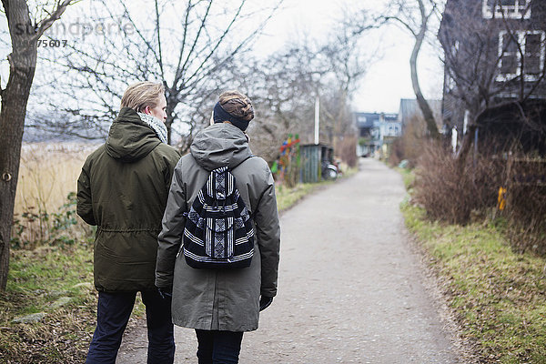 Ein Paar spaziert einen Weg im Bohème-Viertel Christianshavn entlang  wo die Bewohner ihre Gemeinde als eine von Kopenhagen getrennte Einheit betrachten; Christianshavn  Dänemark'