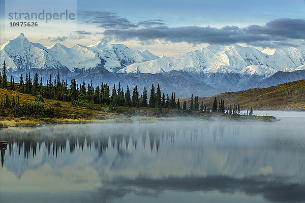 Blick auf den Sonnenaufgang über den Mount Brooks und die Alaska Range mit Nebel über dem Wonder Lake im Vordergrund  Denali National Park  Interior Alaska  Herbst