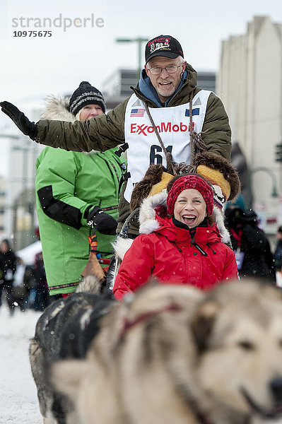 Jeff King und sein Team verlassen die feierliche Startlinie mit einem Iditarider während des Iditarod 2016
