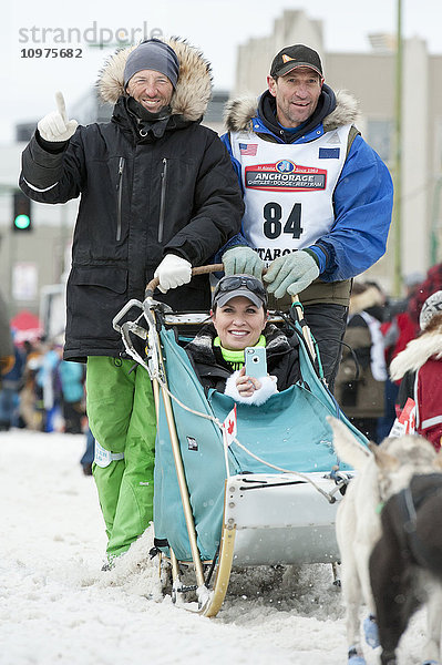 Hans Gatt und sein Team verlassen die feierliche Startlinie mit einem Iditarider während des Iditarod 2016