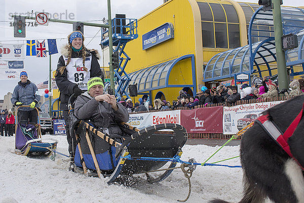 Kristy Berington und ihr Team verlassen die feierliche Startlinie mit einem Iditarider während des Iditarod 2016