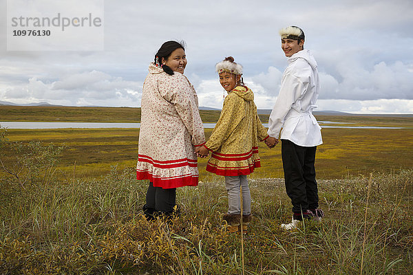 Ein junger Yupik-Inupiag-Eskimo und ein Yupik-Eskimo-Mädchen stehen mit Blick auf die sommerliche Tundra und das Land außerhalb von Nome  Alaska