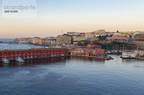 Eine weite Landschaftsansicht des Hafens von Neapel  dem Sitz der italienischen Marine  im Vordergrund mit der historischen Altstadt von Neapel im Hintergrund in der Morgendämmerung; Neapel  Kampanien  Italien