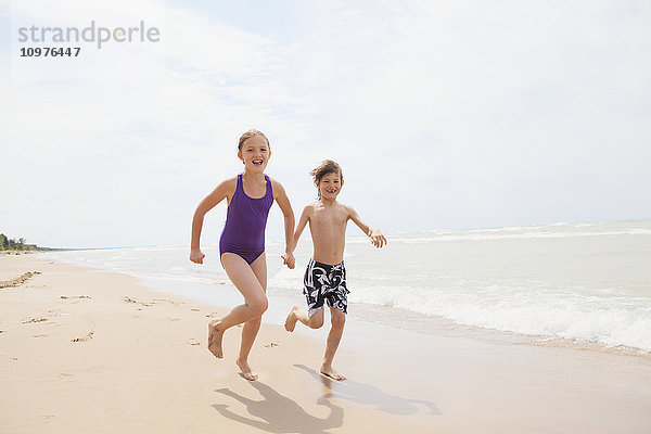 Junge und Mädchen laufen am Strand; Grand Bend  Ontario  Kanada'.
