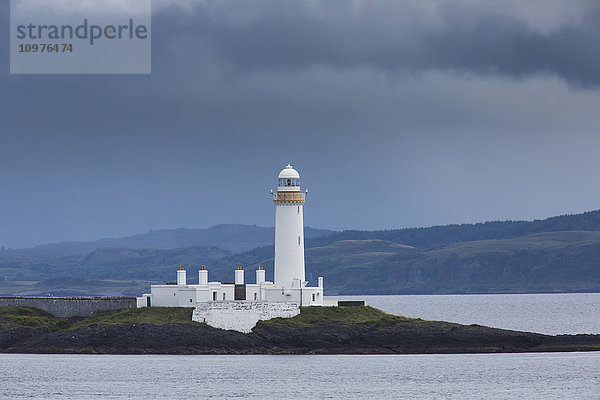 Weißer Leuchtturm unter Gewitterwolken an der Küste; Schottland'.