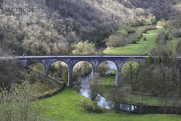Eine Brücke mit Bögen über einen kleinen Fluss in einem Tal; Derbyshire  England