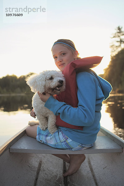 Mädchen sitzt mit ihrem Hund in einem Kanu auf dem Crystal Lake; Ontario  Kanada'.