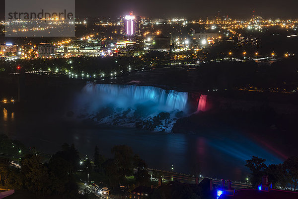Nachtansicht der American Falls vor den Lichtern der Stadt; Niagarafälle  New York  USA'.
