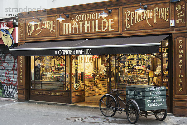 Die reich verzierte Fassade eines traditionellen Schokoladengeschäfts mit einem antiken Lieferwagen davor; Paris  Frankreich'.