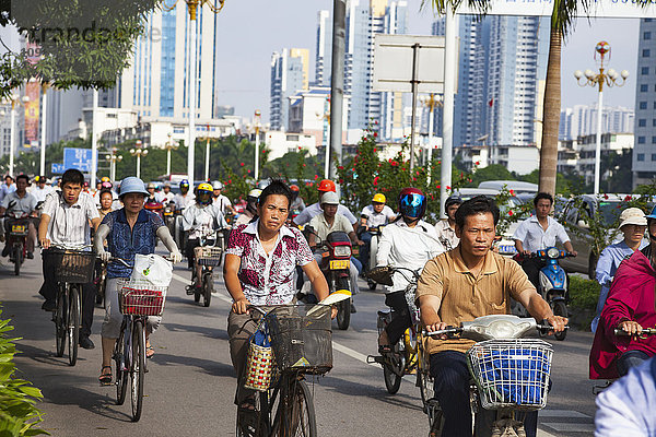 Menschen  die frühmorgens auf Fahrrädern und Motorrollern auf einer separaten Fahrspur pendeln; Nanning  Guangxi  China