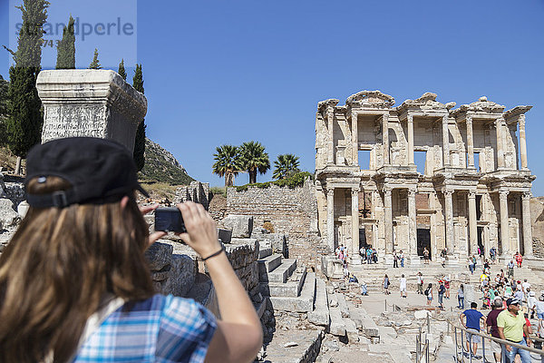 Eine Touristin fotografiert die Bibliothek des Celsus in den Ruinen von Ephesus; Ephesus  Izmir  Türkei'.