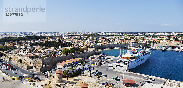Panoramablick auf die Skyline des Hafens von Rhodos  Griechenland  mit einem kleinen Kreuzfahrtschiff und Blick auf die historische Stadtmauer in der Ägäis; Rhodos  Griechenland'.