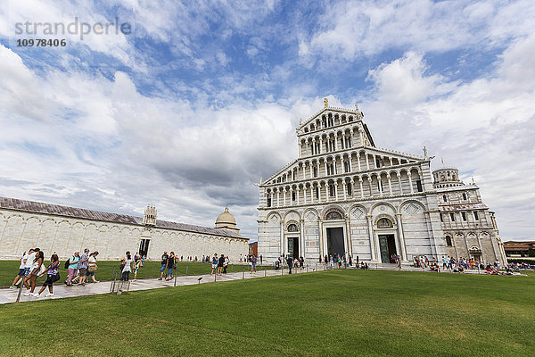 Touristen spazieren über die Piazza Dei Miracoli und besuchen die historische Stätte und den Schiefen Turm von Pisa; Pisa  Siena  Italien'.