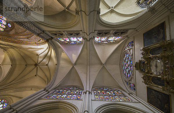 Niedriger Blickwinkel auf eine verzierte Decke mit Buntglasfenstern und einer Uhr; Toledo  Kastilien-La Mancha  Spanien'.
