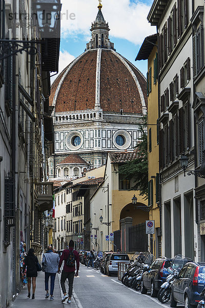 Fußgänger auf einer Straße mit der Kuppel der Kathedrale von Florenz; Florenz  Italien'.