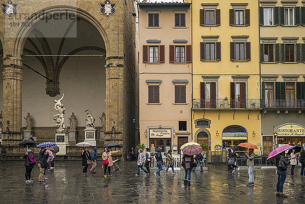 Fußgänger auf einem Stadtplatz an einem regnerischen Tag; Florenz  Italien'.