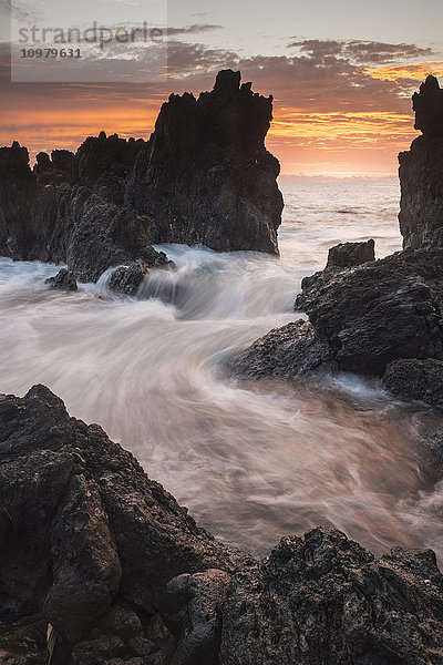 Die Brandung dringt bei Sonnenaufgang durch die Felsen; Laupahoehoe  Insel Hawaii  Hawaii  Vereinigte Staaten von Amerika'.