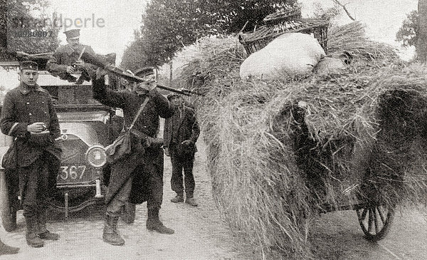 Soldaten auf der Suche nach deutschen Spionen durchsuchen einen Heuwagen mit Bajonetten in Aarschot  Belgien  während des Ersten Weltkriegs. Aus The War Illustrated Album Deluxe  veröffentlicht 1915.