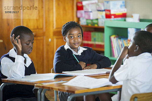 Junge Schüler arbeiten in einem Klassenzimmer; Hammanskraal  Gautang  Südafrika'.