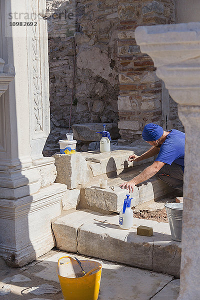 Ein männlicher Archäologe arbeitet mit feinen Werkzeugen an der heiklen Aufgabe der Restaurierung und Wiederherstellung der Ruinen von Ephesus; Ephesus  Türkei'.