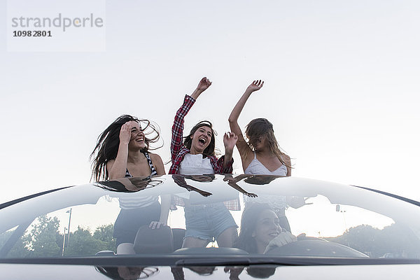 Freunde tanzen im Cabriolet