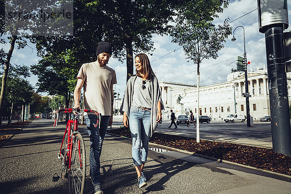 Österreich  Wien  junges Paar mit Fahrrad vor dem Parlamentsgebäude
