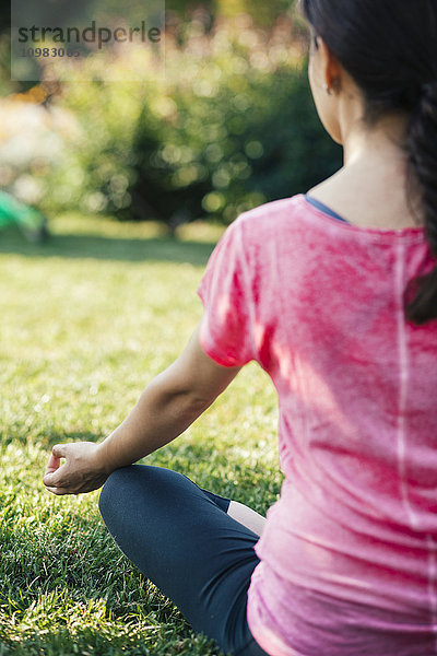 Junge Frau beim Meditieren im Park