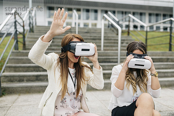 Zwei Frauen haben Spaß mit einer VR-Brille im Freien