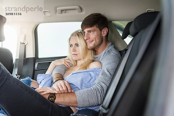 Verliebtes Paar auf dem Rücksitz eines Autos