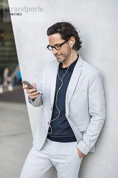 Geschäftsmann mit Smartphone und Kopfhörer