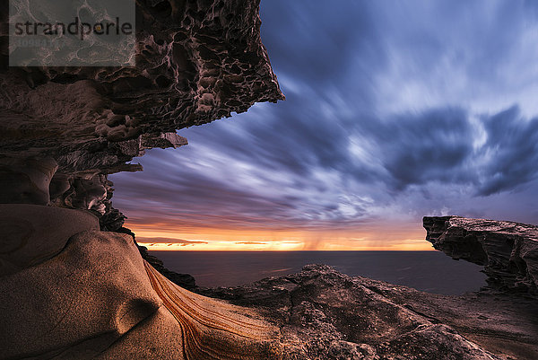 Australien  New South Wales  Felsformation und dramatischer Himmel bei Sonnenuntergang