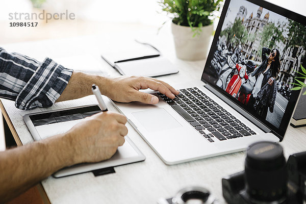 Fotograf am Schreibtisch mit Laptop und Grafiktabletts  Teilansicht