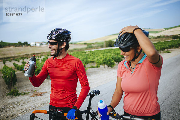 Spanien  Andalusien  Jerez de la Frontera  ein paar Radfahrer trinken Wasser auf einer Landstraße zwischen Weinbergen.