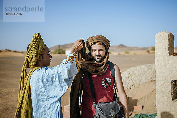 Berberführer hilft Touist beim Einwickeln eines Turbanes
