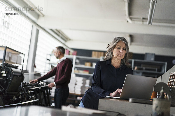 Senior Frau eine Druckerei mit Laptop