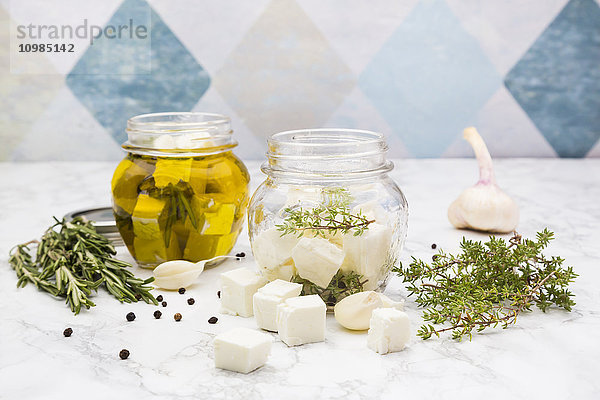 Glas gewürfelter Schafskäse in Olivenöl  Thymian  Knoblauch  Pfeffer und Rosmarin eingelegt