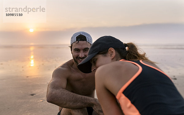 Spanien  Aviles  Athleten Paar Training am Strand bei Sonnenuntergang